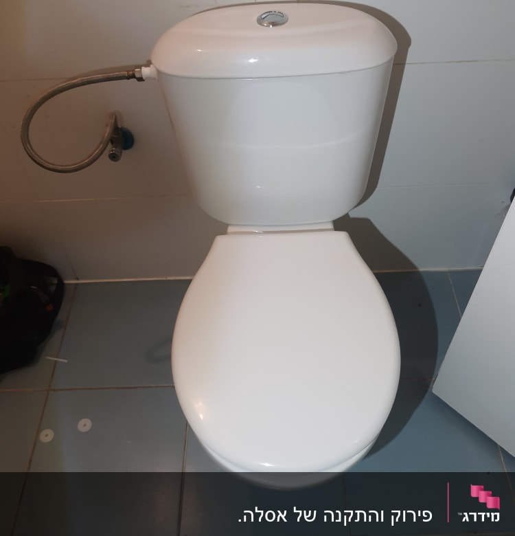 אסלה עם צינור מים מחובר לקיר
